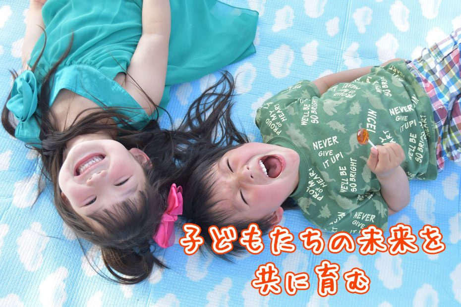 笑顔で寝転ぶ子どもたち「子どもたちの未来を共に育む」